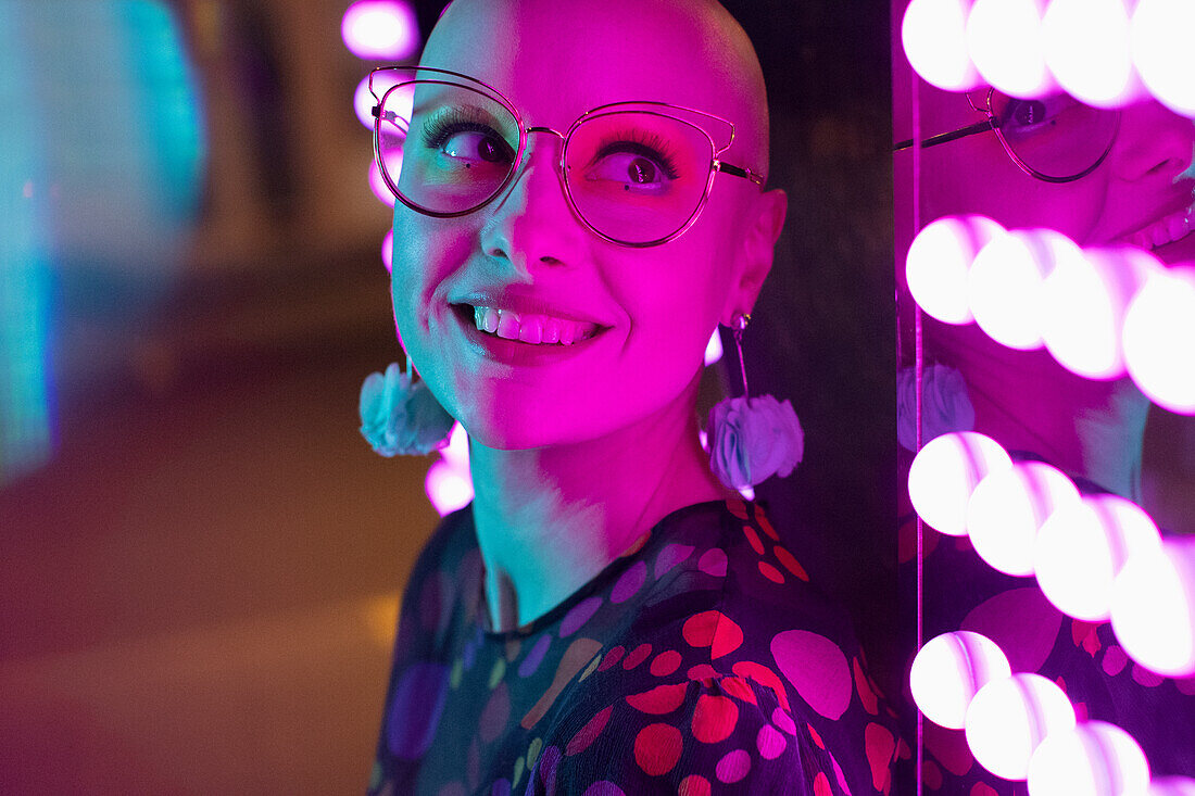 Woman with shaved-head, head by neon light