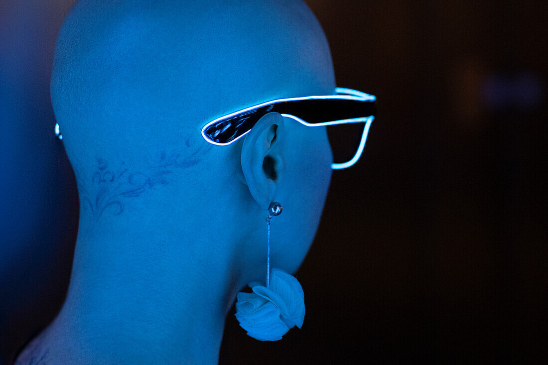 Woman with shaved head wearing neon eyeglasses