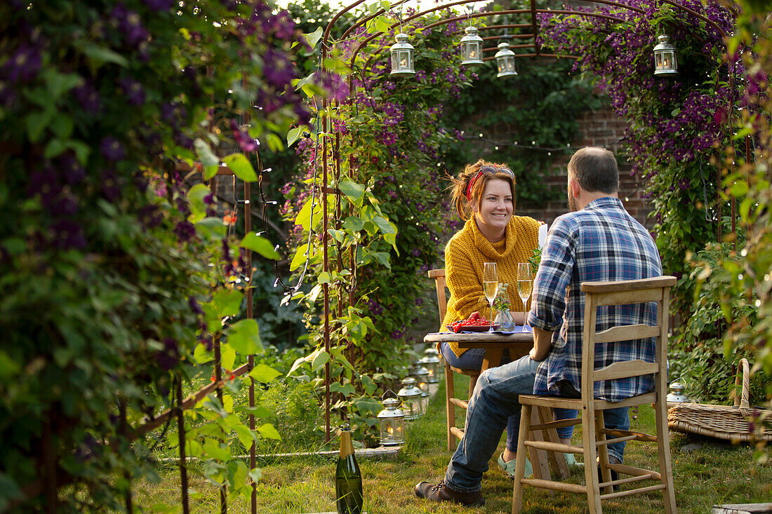 Happy couple enjoying champagne in summer garden