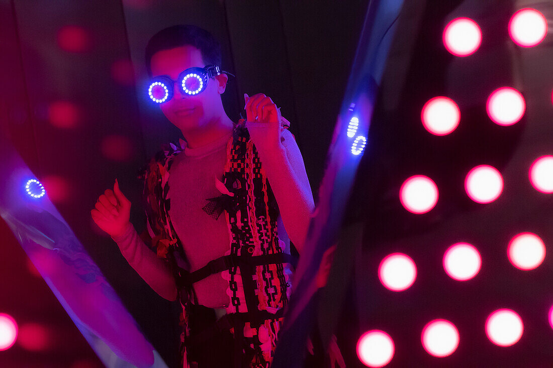 Young man in futuristic neon glasses at nightclub
