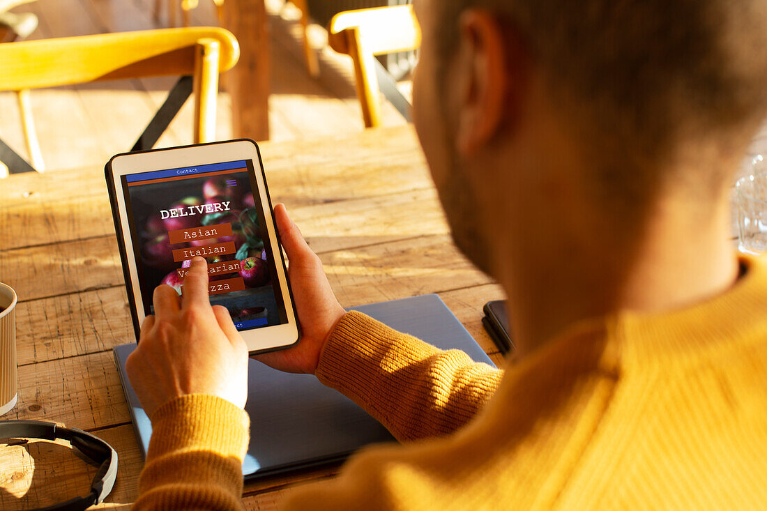 Man with digital tablet ordering food by app