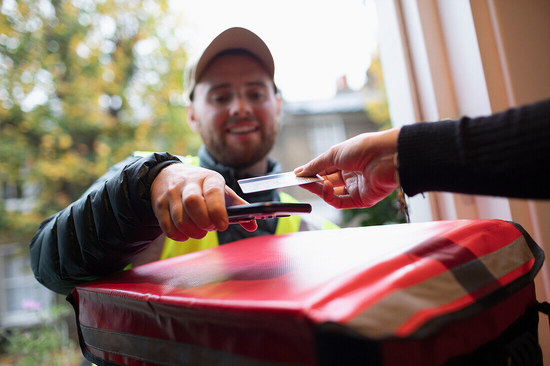 Customer paying delivery man with contactless card