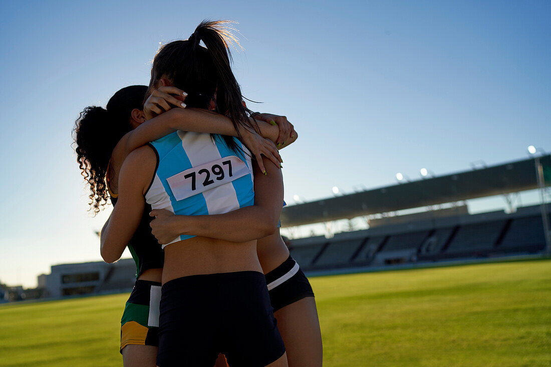 Happy athletes hugging in stadium