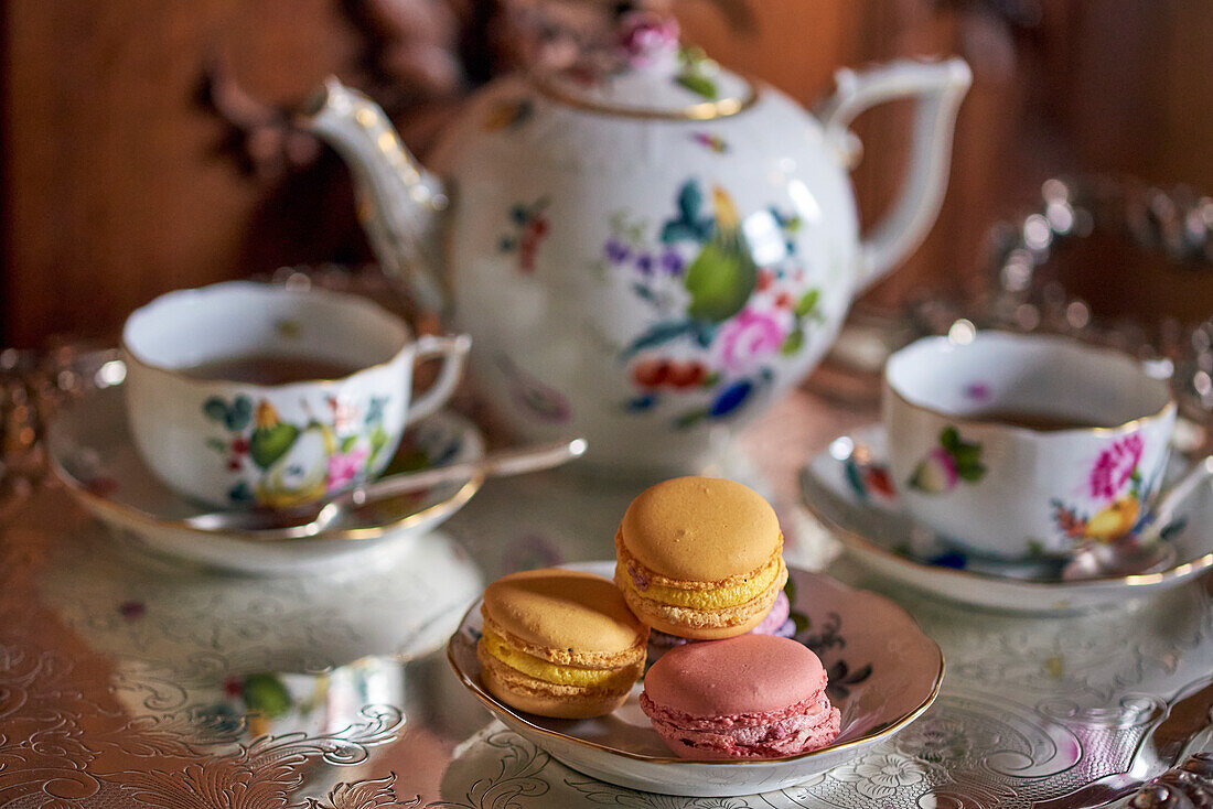 Macarons und elegantes Teeservice auf Silbertablett