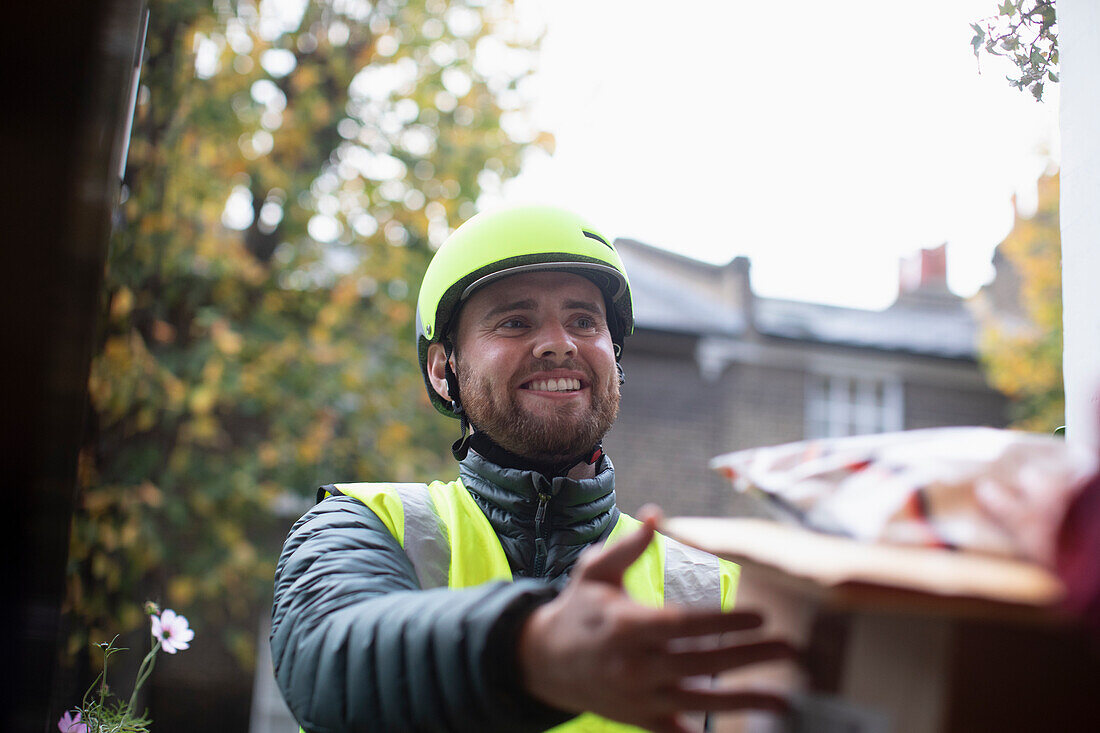 Happy friendly courier in helmet making delivery