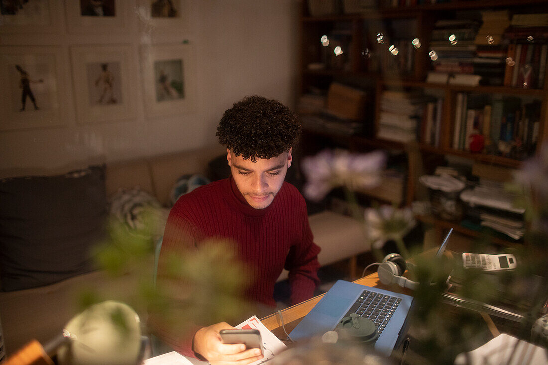 Young man with smart phone working from home