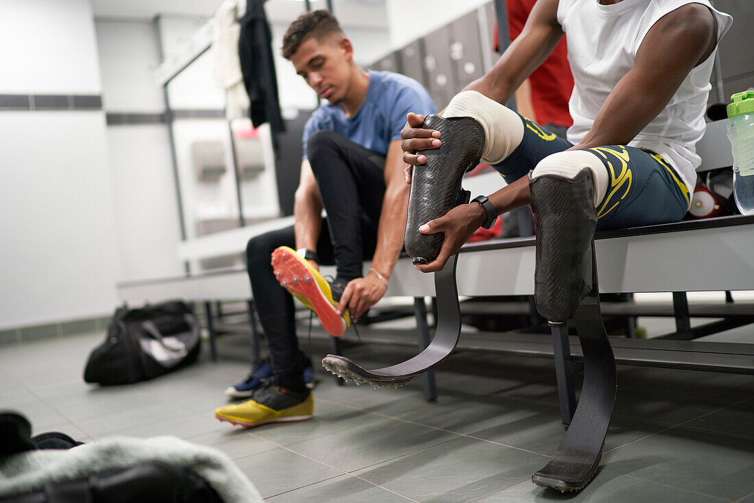 Male amputee athlete adjusting running blade prosthetic
