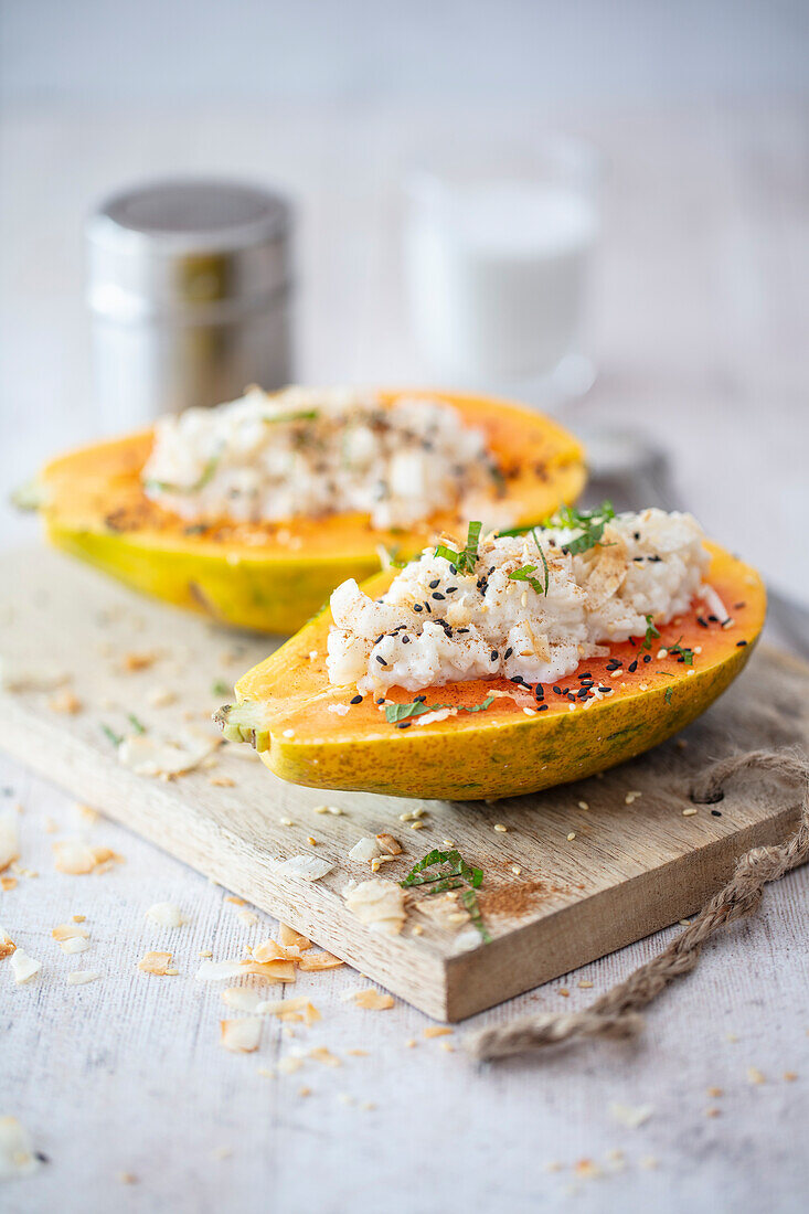 Papaya gefüllt mit Kokosmilchreis, Kokoschips und Zimt (vegan)
