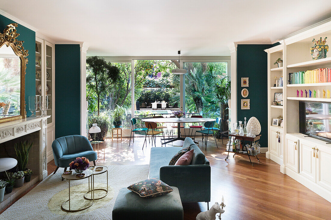 Open-plan interior with green walls and dining area in front of glass wall