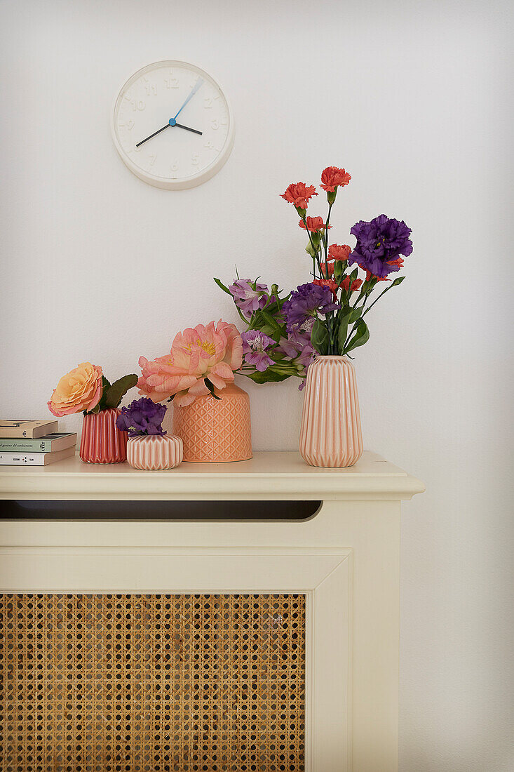 Vases of flowers on top of radiator cover