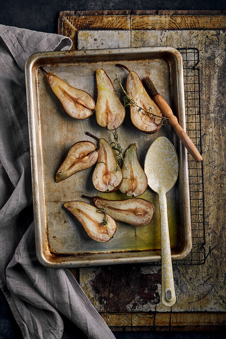 Baked pears with thyme on a baking tray