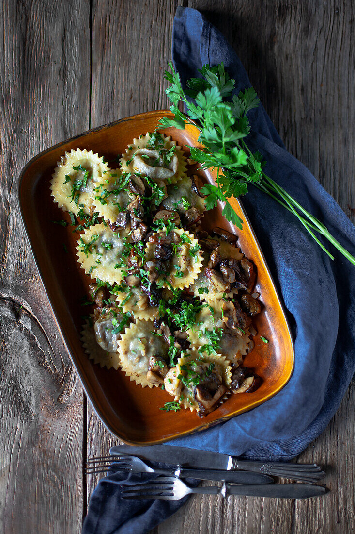 Runde Ravioli mit Pilzsauce und Kräutern