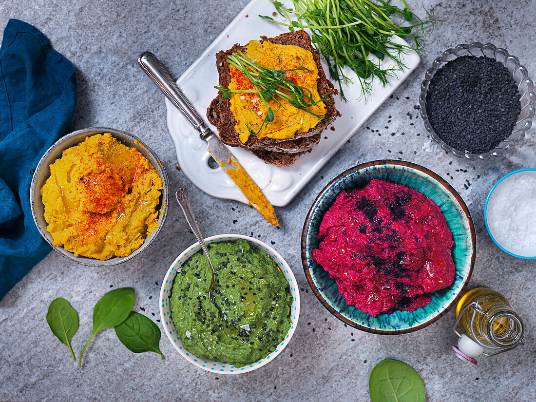 Beetroot hummus, hummus with spinach and black sesamy seeds and hummus with carrots