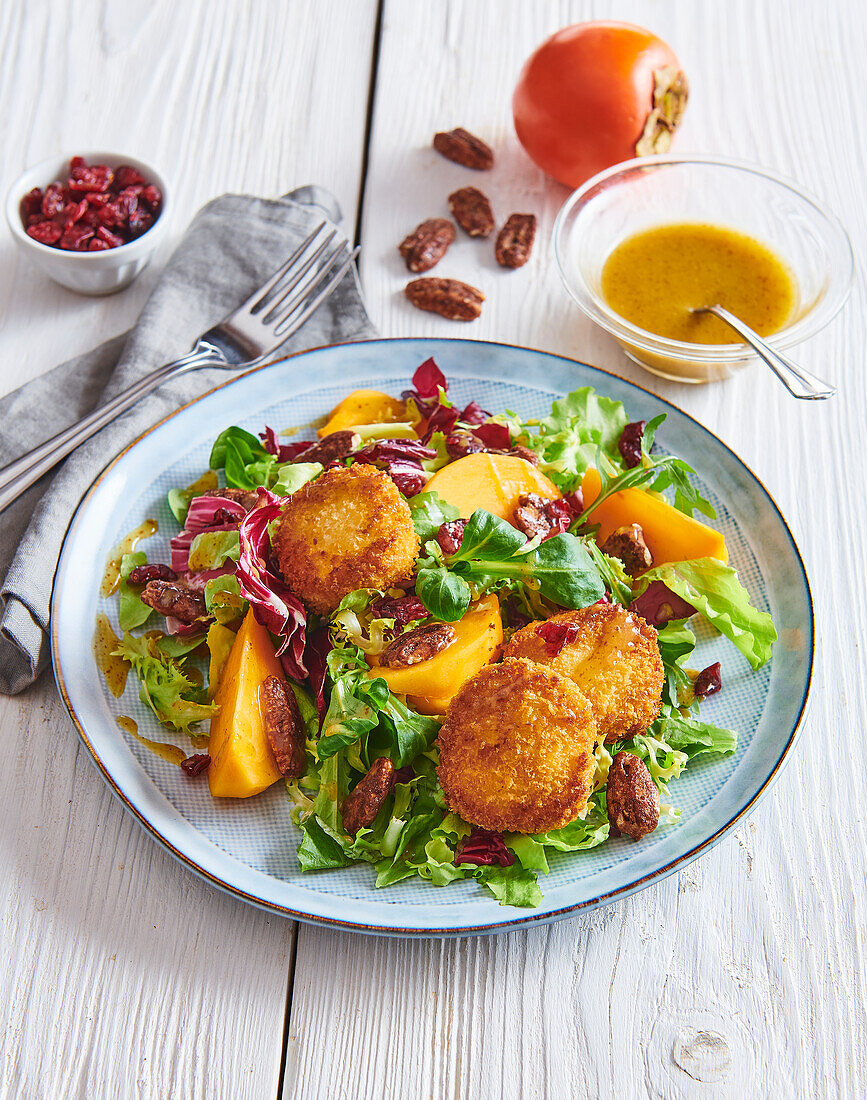 Salad with breaded goat cheese, persimmon, and pecans