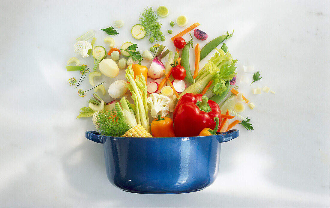 Fresh vegetable ingredients dropped into a saucepan