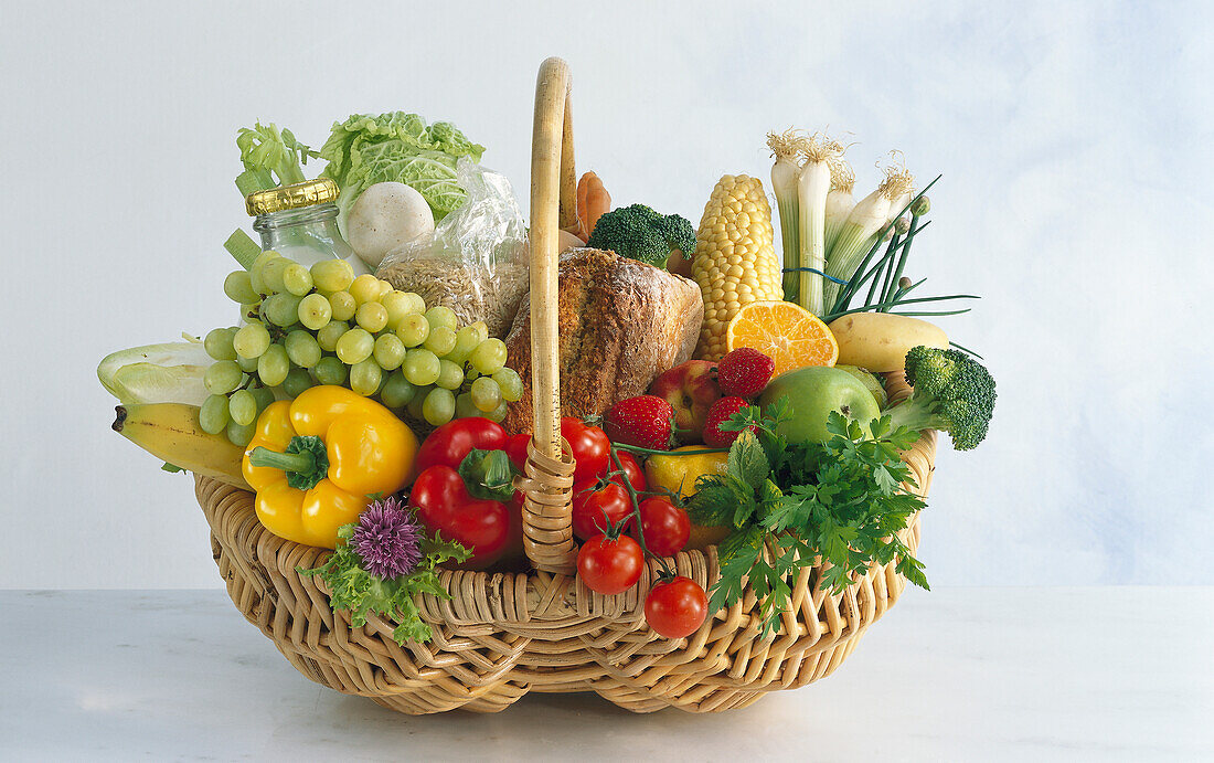 Korb mit gesunden Lebensmitteln: frisches Obst und Gemüse, Milch, Vollkornbrot