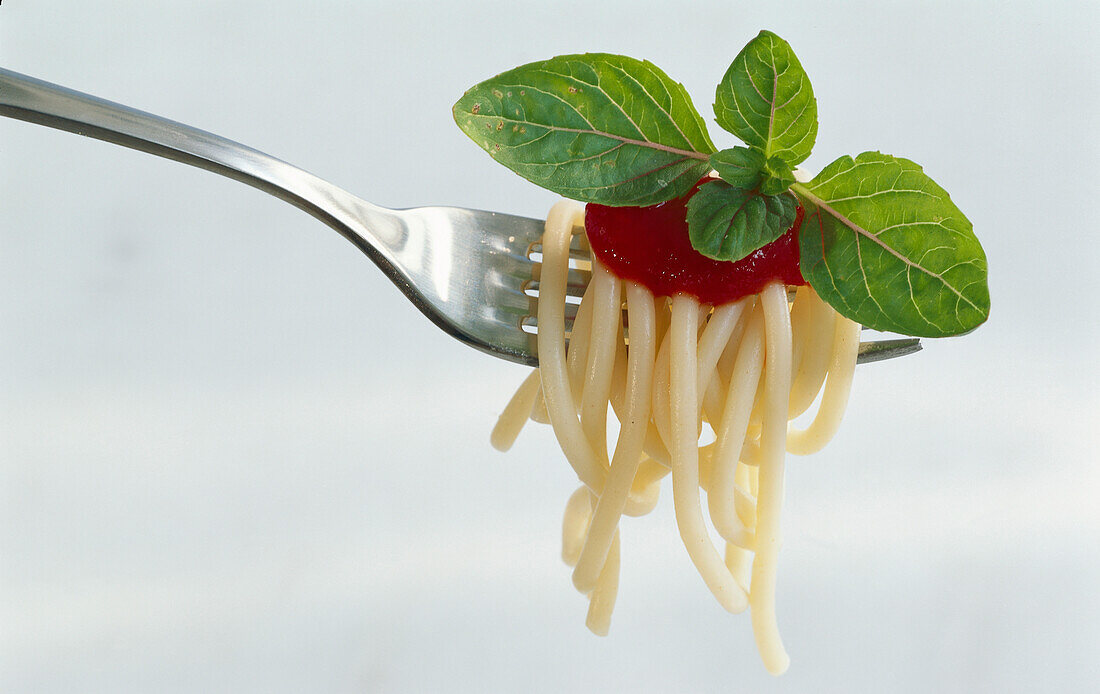 Gabel mit Spaghetti, Tomatensauce und Basilikum