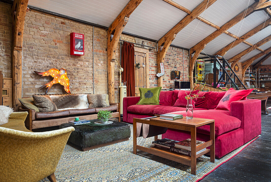 Open, eclectic living room with various sofas and brick wall