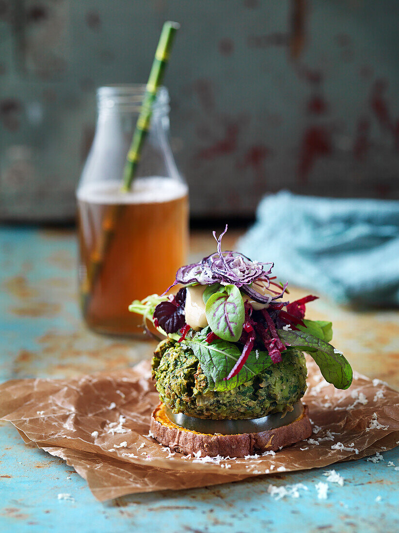 Veganer Edamame Bean Burger mit Salat, gerösteten Süßkartoffeln und Zwiebeln