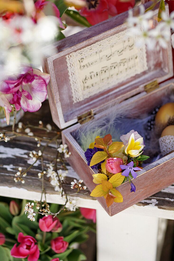 Posy, Easter eggs and feathers in a wooden box