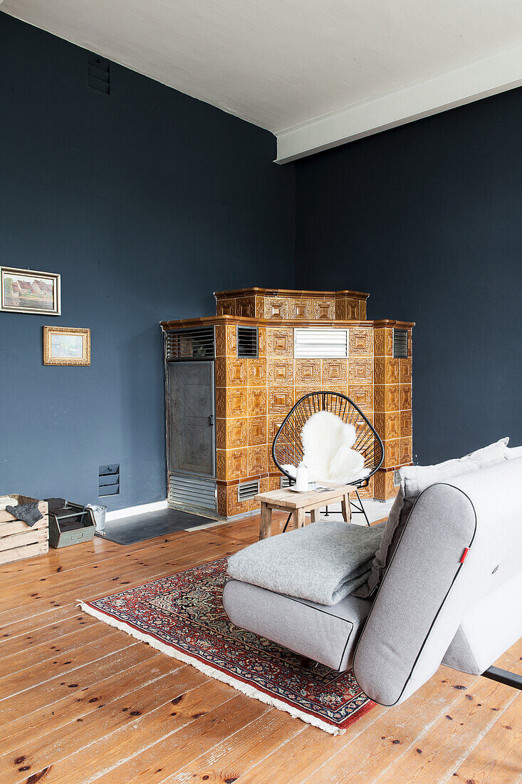 Tiled stove in corner of room with blue-painted walls