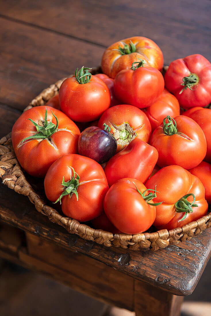 Bowl of organic tomatoes on a dark wooden table