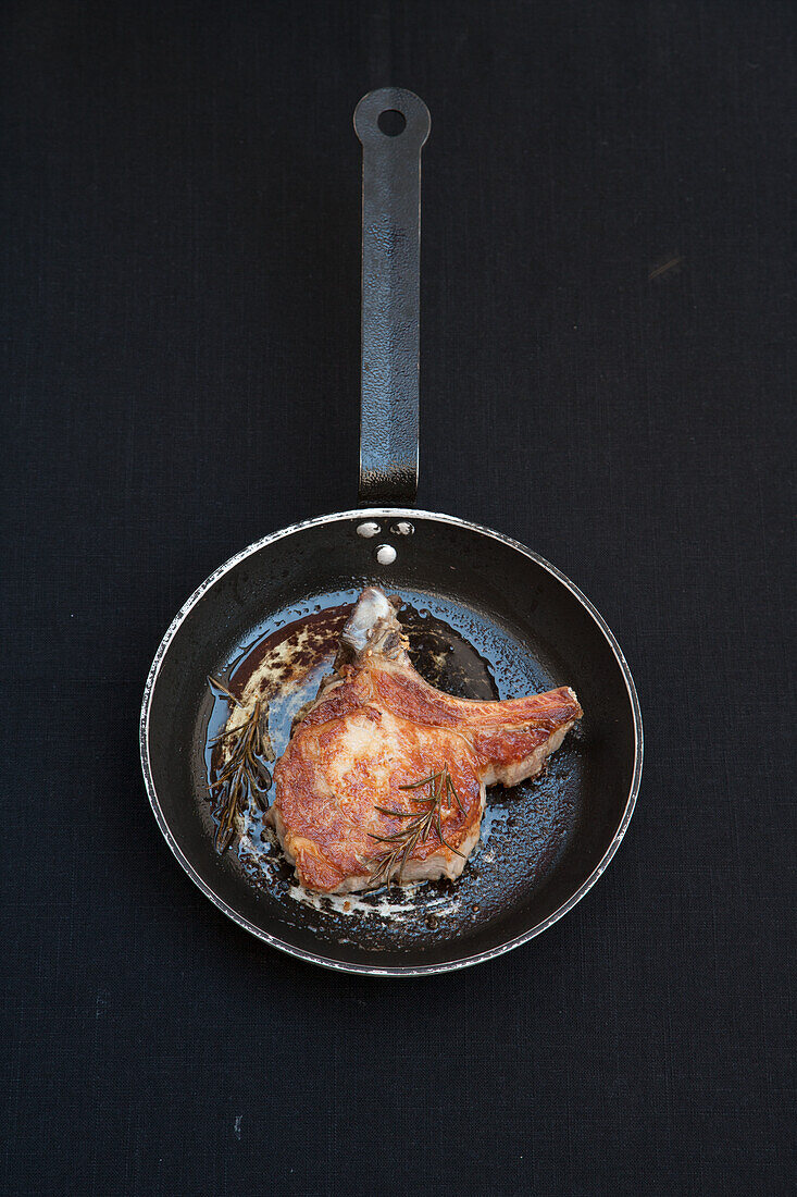 Fried pork chop with butter and rosemary
