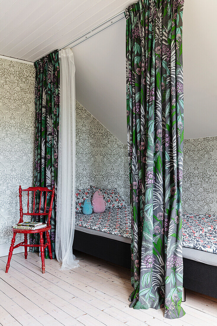 Two beds in sibling's bedroom with patterned curtains and wallpaper