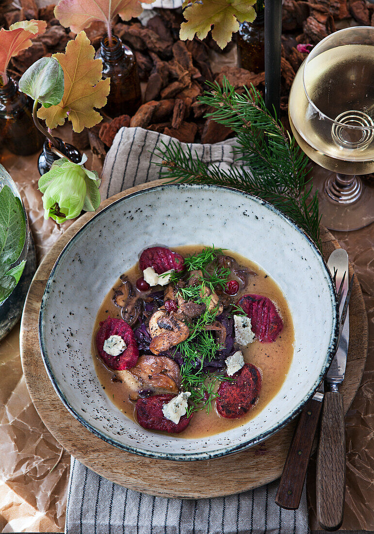 Mushroom broth with beetroot dumplings, cheese, dill, mushrooms and red cabbage