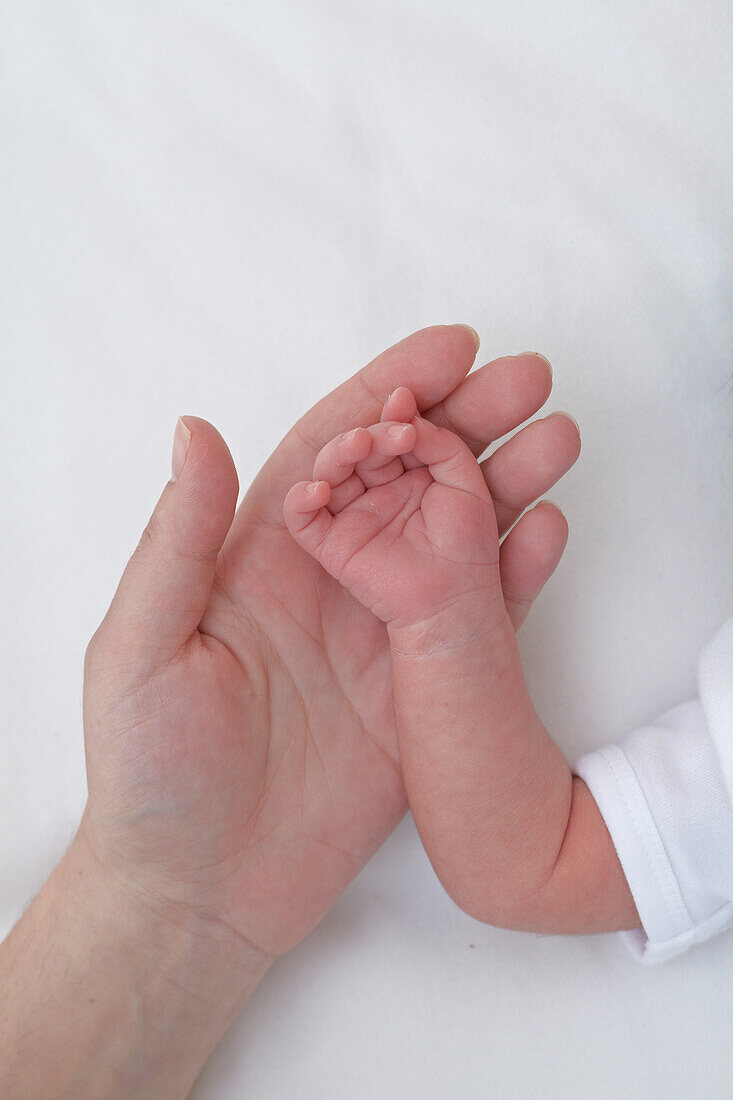 Baby girl's hand on woman's hand