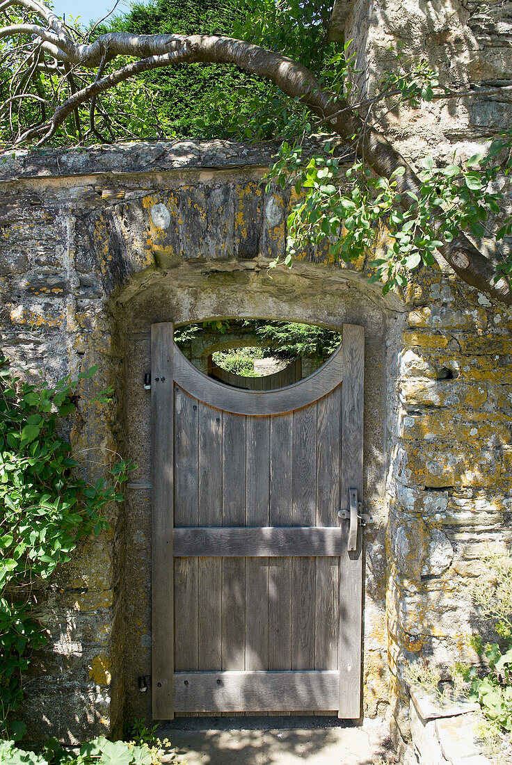Old garden gate in stone wall