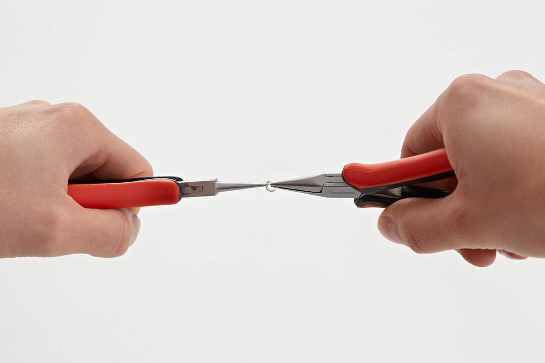 Holding jump ring between two pairs of pliers