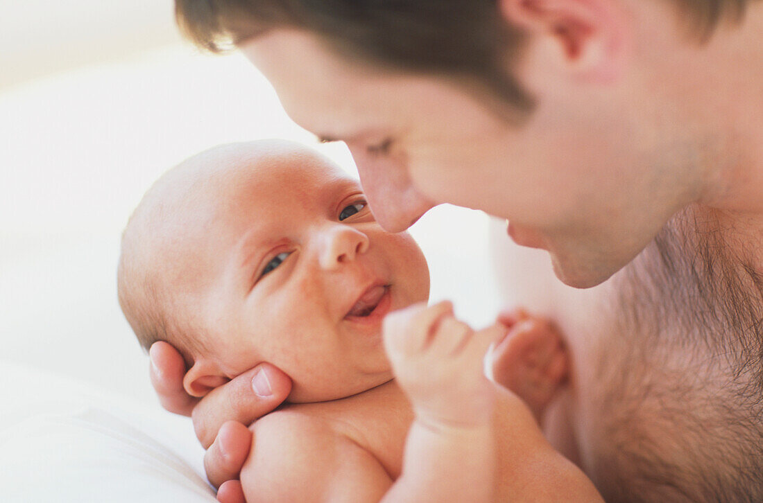 Man holding young baby close to his chest