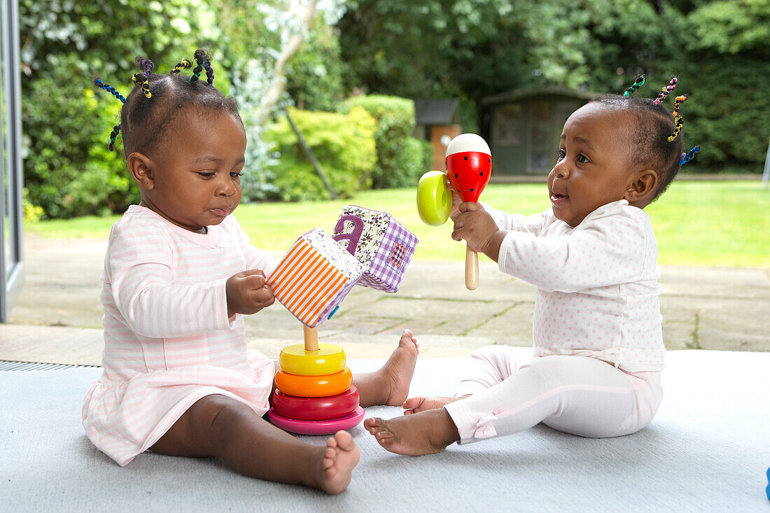 Twin girls playing with toys on floor