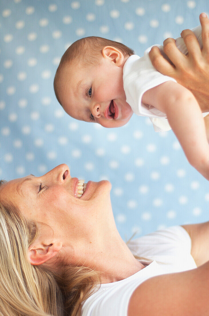 Woman lifting baby above head