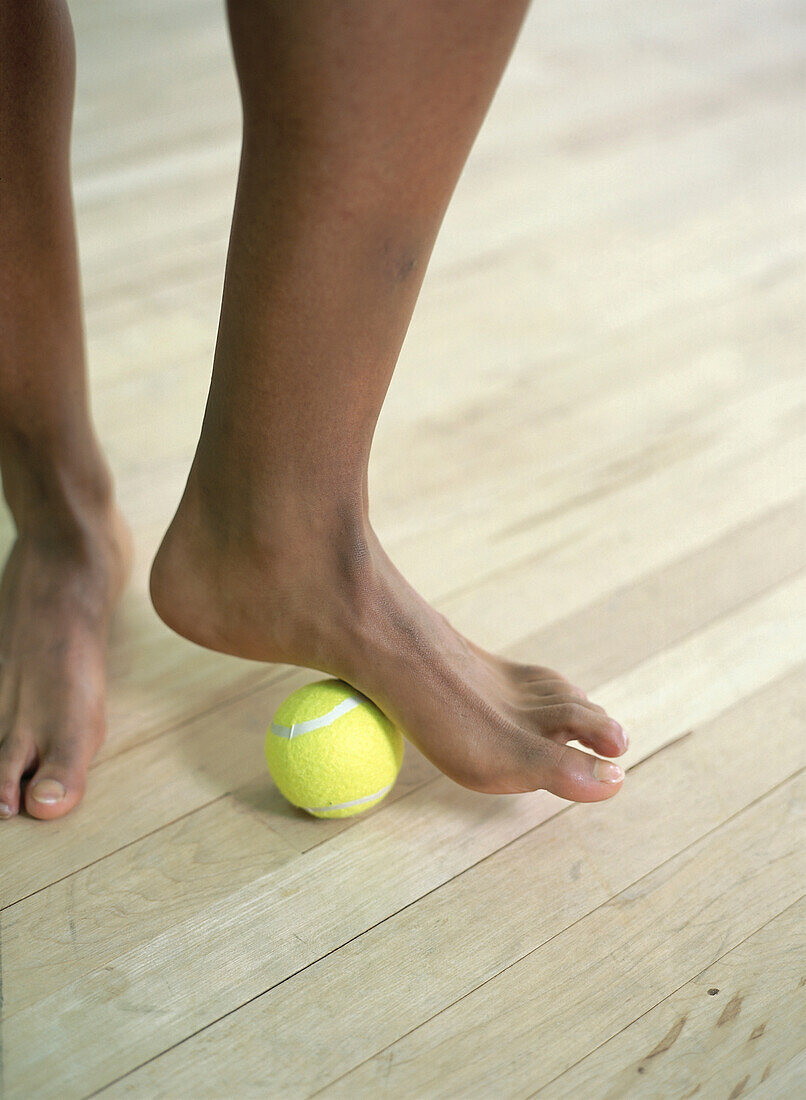 Rolling arch of foot over tennis ball