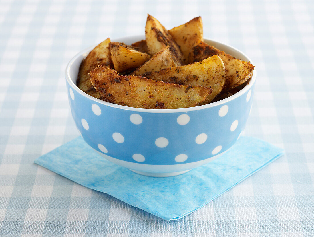 Potato wedges in a blue spotted bowl