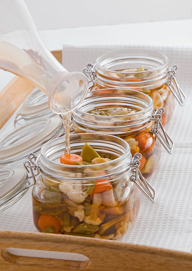 Sauce being poured in pickled jar