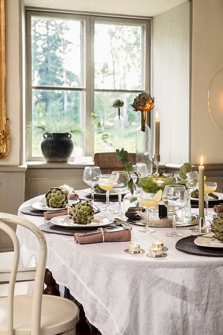 Festively laid table with artichokes as decoration and cocktail