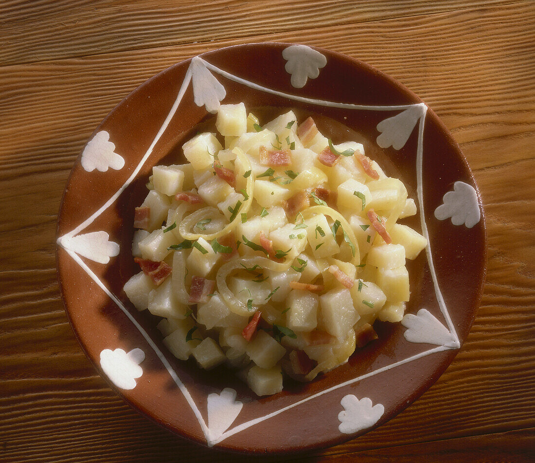 Brown plate of diced potatoes with onion and bacon