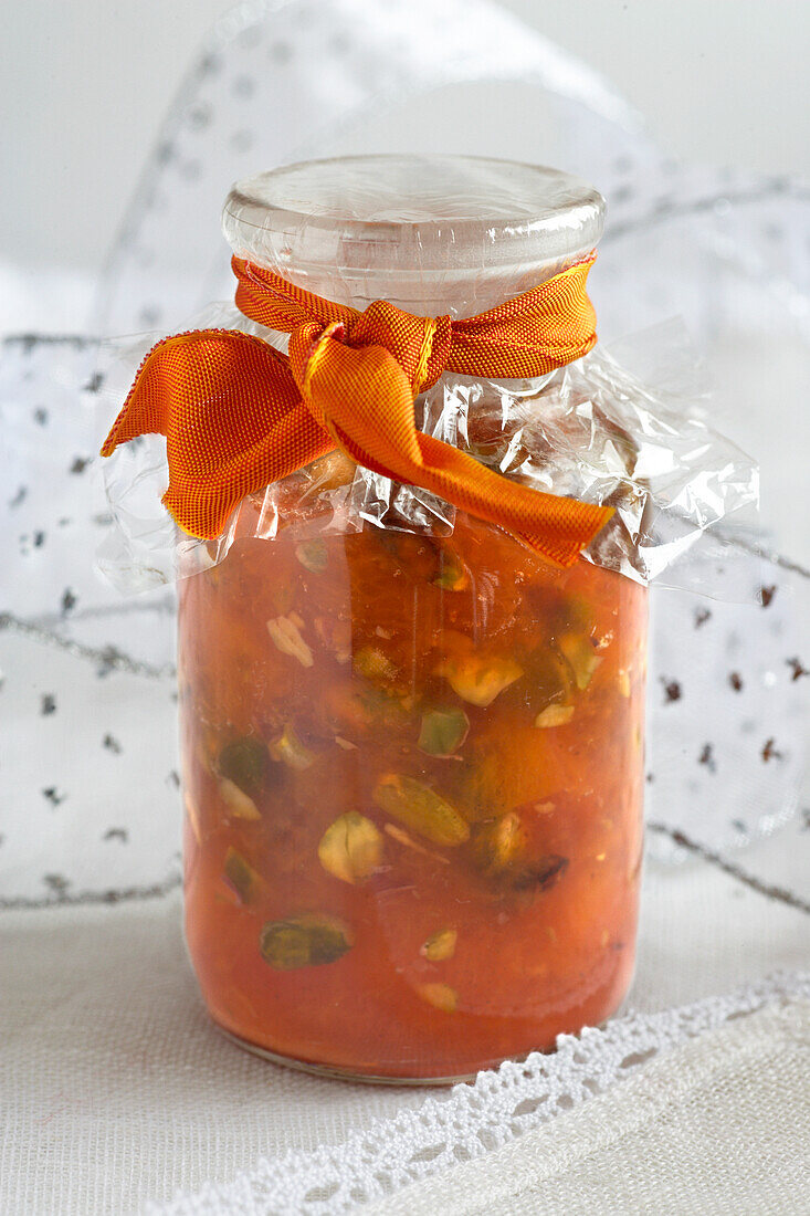 Peach and pistachio preserve in jar with seal