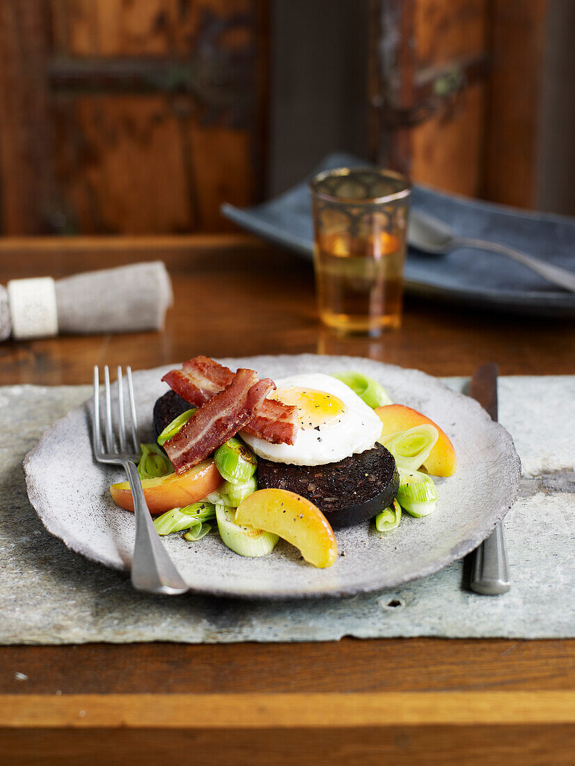 Black pudding with apples, leek, fried egg and bacon