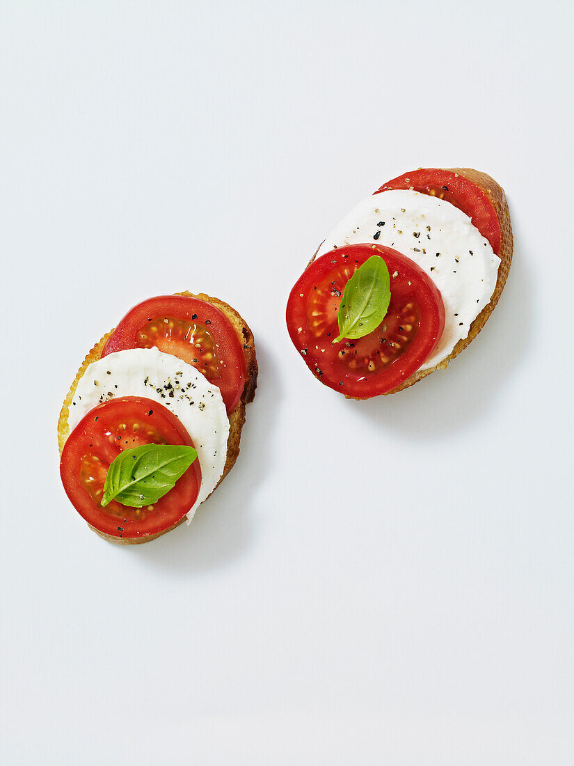 Bread topped with mozzarella cheese, tomato and basil