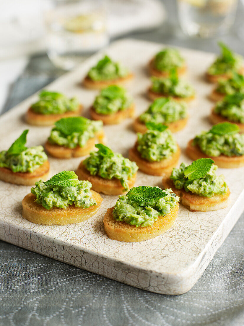 Minted crushed pea and lettuce crostini with mint sprigs