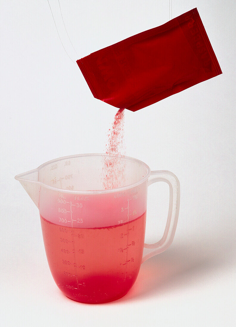 Packet of jelly crystals suspended over a jug of water