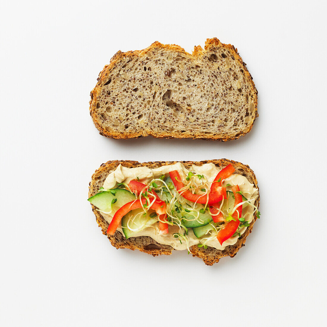 Seeded bread sandwich with vegetables, sprouts and hummus