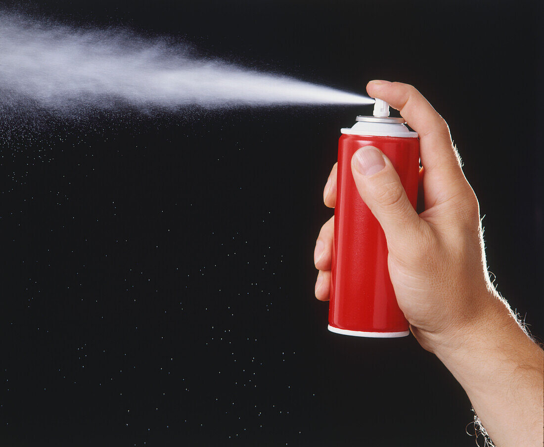 Pushing sprayer button on aerosol can