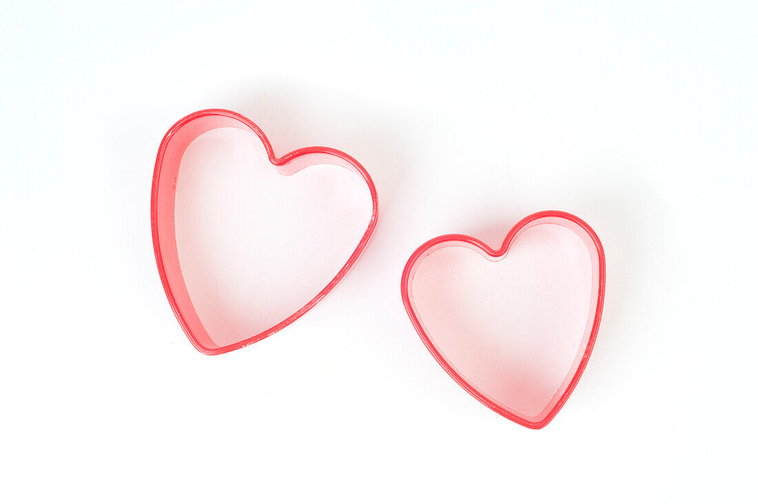 Two small red plastic heart-shaped pastry cutters