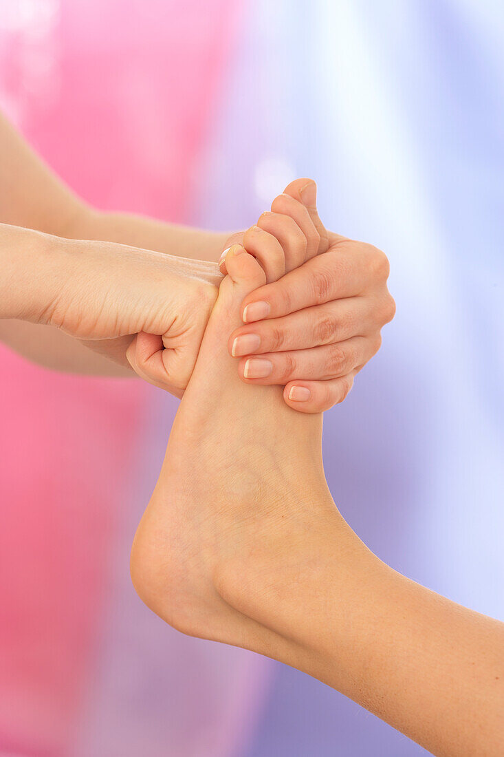 Reflexologist pushing fist against sole of child's foot