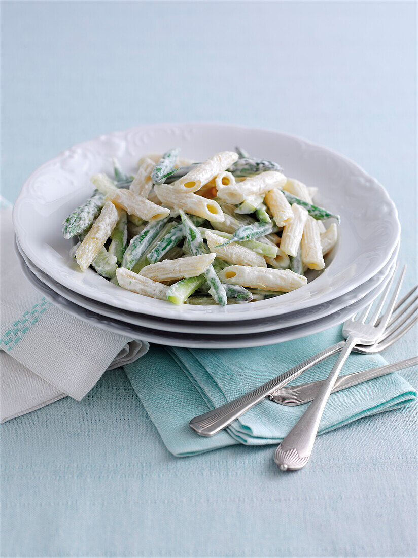 Penne pasta with asparagus tips in creamy sauce